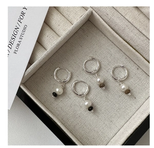 Vue macro de boucles d'oreilles créoles en argent S925 avec fil torsadé et perles