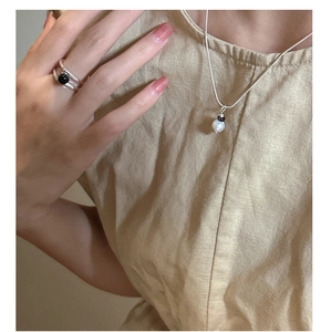 Gros plan d'une bague en argent S925 avec pierre noire et fils torsadés superposés