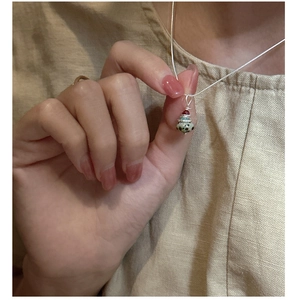 Gros plan du collier Saturne en argent S925 avec pendentif en pierre naturelle tachetée