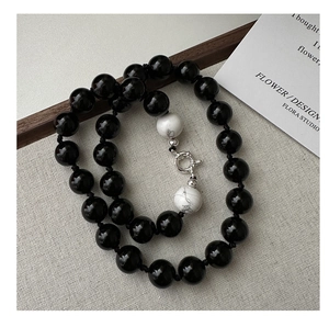 Detail of S925 silver necklace featuring black agate and white turquoise beads with a sailor clasp