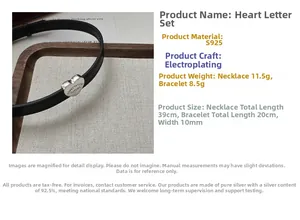 Detail of s925 silver heart necklace and bracelet set with engraved letters on suede