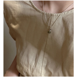 Détail du collier Saturne en argent S925 avec pendentif en pierre naturelle verte sur modèle