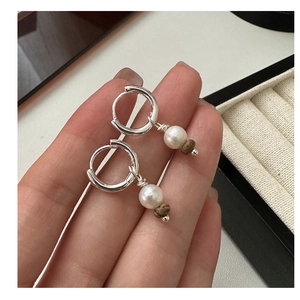Détail de boucles d'oreilles S925 en argent avec perle et perle marron naturel