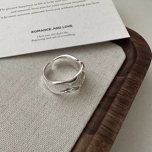 Anello a onde in argento s925 con design geometrico irregolare su vassoio in legno