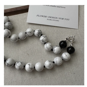 Detail of beaded S925 silver necklace featuring white turquoise and black onyx beads