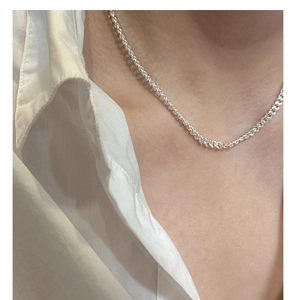 Close-up of minimalist S925 sterling silver curb chain worn on neck with white shirt