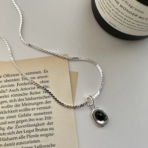 Elegante S925 Sterling Silber Schlangenkette mit schwarzem Onyx Anhänger auf Vintage Papier