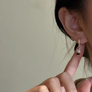 Boucles d'oreilles perles en argent portées montrant un design de bijoux rétro minimaliste