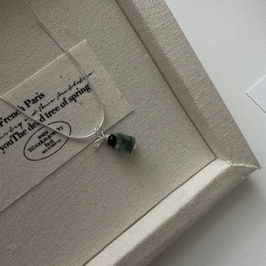 Vintage S925 silver necklace with green rectangular gemstone pendant on a beige jewelry tray