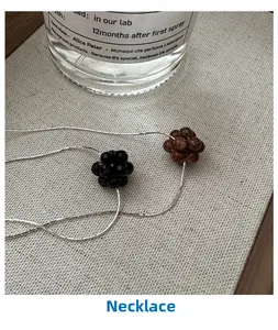 Detail of s925 sterling silver necklaces with black faceted beads and brown goldstone charms