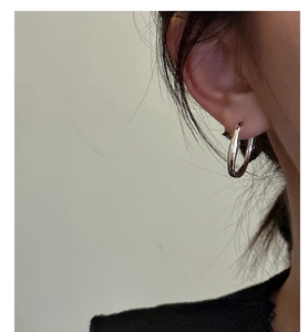 Close-up of minimalist silver hoop earrings worn by a model for a modern look