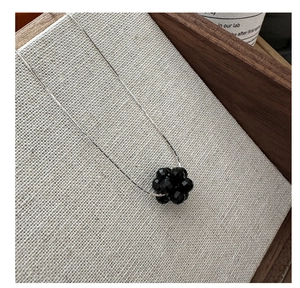 Detailed close-up of a s925 silver necklace featuring a black beaded fruit cluster pendant