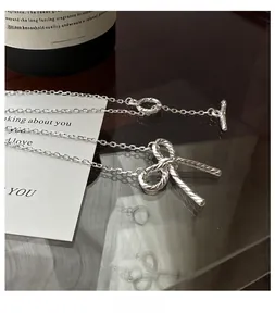 Detailed close-up of S925 silver bow pendant with rope texture and unique toggle clasp
