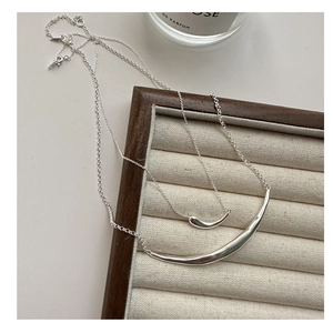 Detailed close-up of S925 sterling silver smile pendants with curved matte finish