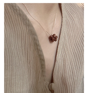 Detail of s925 silver necklace with brown glitter bead pendant on a woman neck