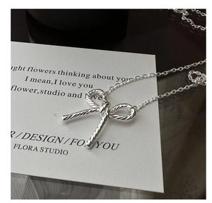 Macro detail of S925 sterling silver bow knot pendant with elegant spiral rope textures