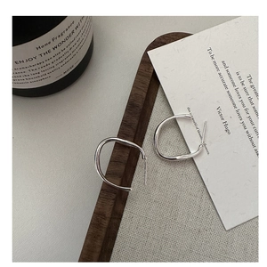 Minimalist S925 sterling silver C-shaped hoop earrings on a wooden jewelry display tray