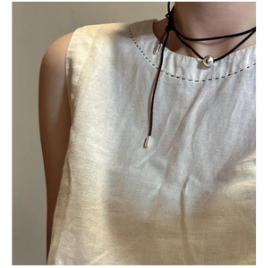 Detail of minimalist S925 sterling silver ball pendant on a black wrap-around rope necklace