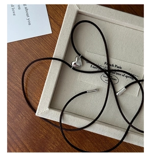 Nahaufnahme des S925 Sterlingsilber Herzanhängers mit Seidenkordel auf Stoffdisplay