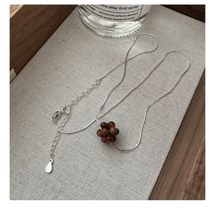 Macro detail of S925 sterling silver chain with autumn berry cluster bead pendant