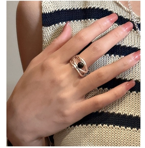 Detail of s925 silver multi-line woven ring featuring a round black agate stone