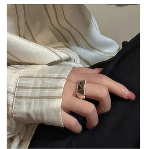 Detail of S925 sterling silver ring with a rectangular black gemstone on model's hand