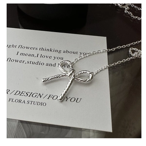 Detailed macro view of S925 sterling silver bow pendant with twisted rope texture
