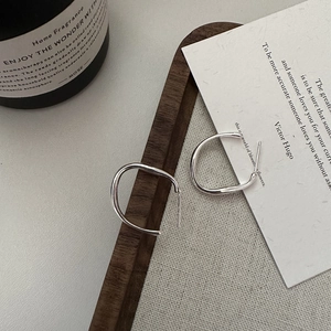Minimalist s925 sterling silver C-shaped irregular earrings on a dark wooden tray