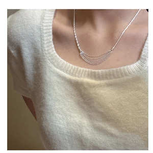 Close-up of five-layer silver bead necklace with spiral chain details on a model