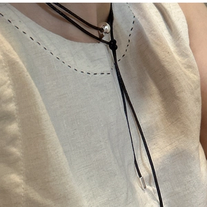 Detail of S925 sterling silver ball pendant on minimalist black cord necklace