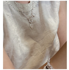 Detalle del conjunto de collar y pulsera con colgante de corazón de plata S925 y cierre OT en modelo