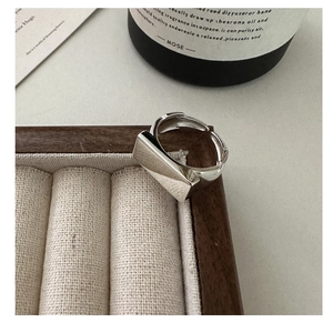 Macro detail of geometric square S925 sterling silver open ring on wooden jewelry tray