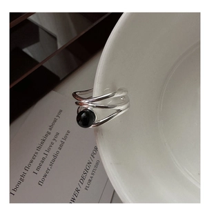 Detail of s925 silver multi-layer ring with black onyx on a white porcelain edge