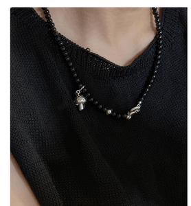 Detailed shot of S925 silver mushroom pendant on black beaded choker with unique clasp