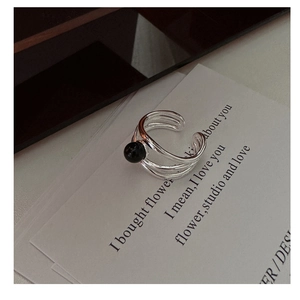 Detail of s925 silver multi-layer geometric ring with black agate bead on card