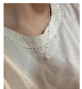 Close-up of S925 sterling silver heart pendant necklace on neck with beaded chain