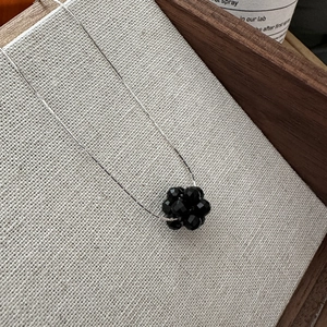 S925 sterling silver necklace with faceted black beaded floral fruit pendant on linen