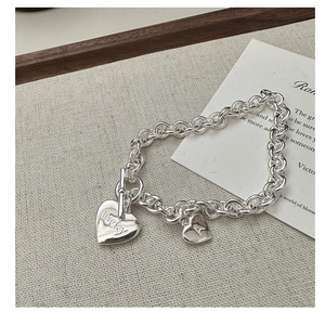 Detail eines S925 Silber OT-Verschluss Armbands mit Herzanhängern und Gravuren