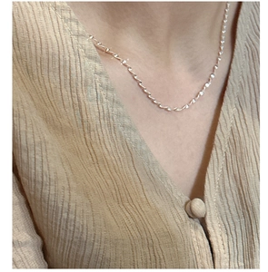 Close-up of elegant S925 silver twist chain necklace in gold finish on female model
