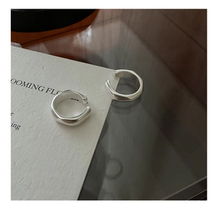 Vista macro di ear cuff in argento opaco con bordi geometrici dalla trama irregolare