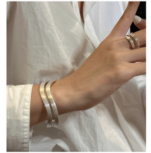 Detailed view of silver multi-layer wavy textured open cuff bracelet and matching ring