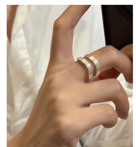 Detail shot of a double-layered S925 silver ring with vertical textures on index finger