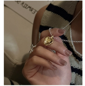 Dettaglio catena a sfere in argento S925 con ciondolo a cuore dorato e incisione LOVE