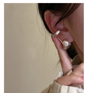 Dettaglio di un earcuff in argento S925 stile metallo liquido e anello a fune intrecciata