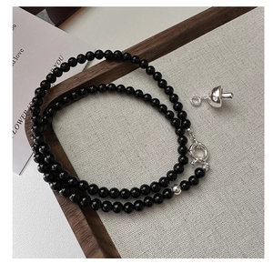 Detail of s925 silver mushroom pendant on a beaded black onyx choker necklace