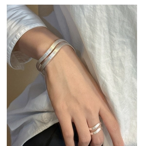 Detail showing layered wave texture on S925 sterling silver bracelets and matching ring
