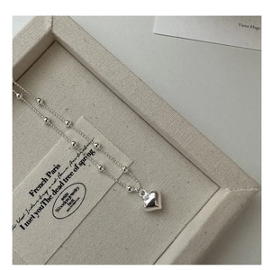 Detailed close-up of s925 silver heart pendant necklace on an elegant jewelry display