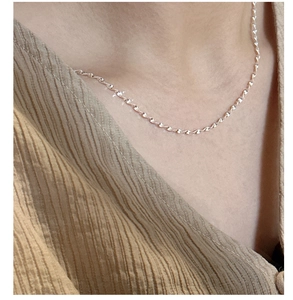 Close-up of S925 sterling silver wavy chain necklace worn on a woman's neck