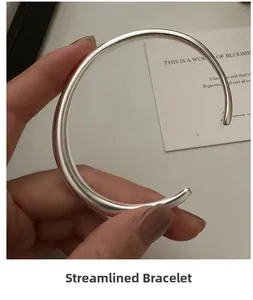Close-up of minimalist S925 sterling silver sleek open bangle with a polished finish