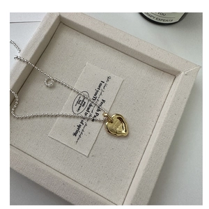 Dettaglio della catena a sfere in argento S925 bicolore con ciondolo a cuore oro